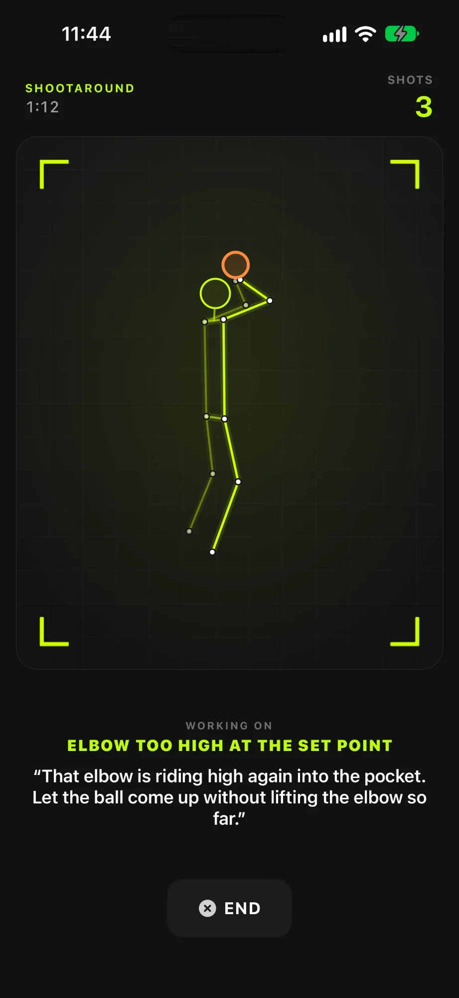 A Shootaround on iPhone, three shots in: a neon skeleton of the shooter inside the camera frame on a plain dark stage, with the coach's cue on screen about the elbow being too high at the set point, above the End button.